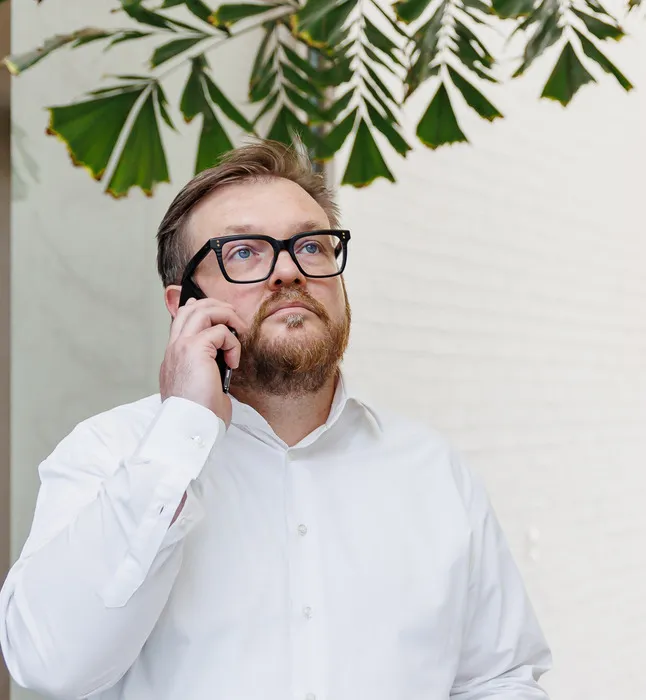 Mand i hvid skjorte snakker i mobiltelefon